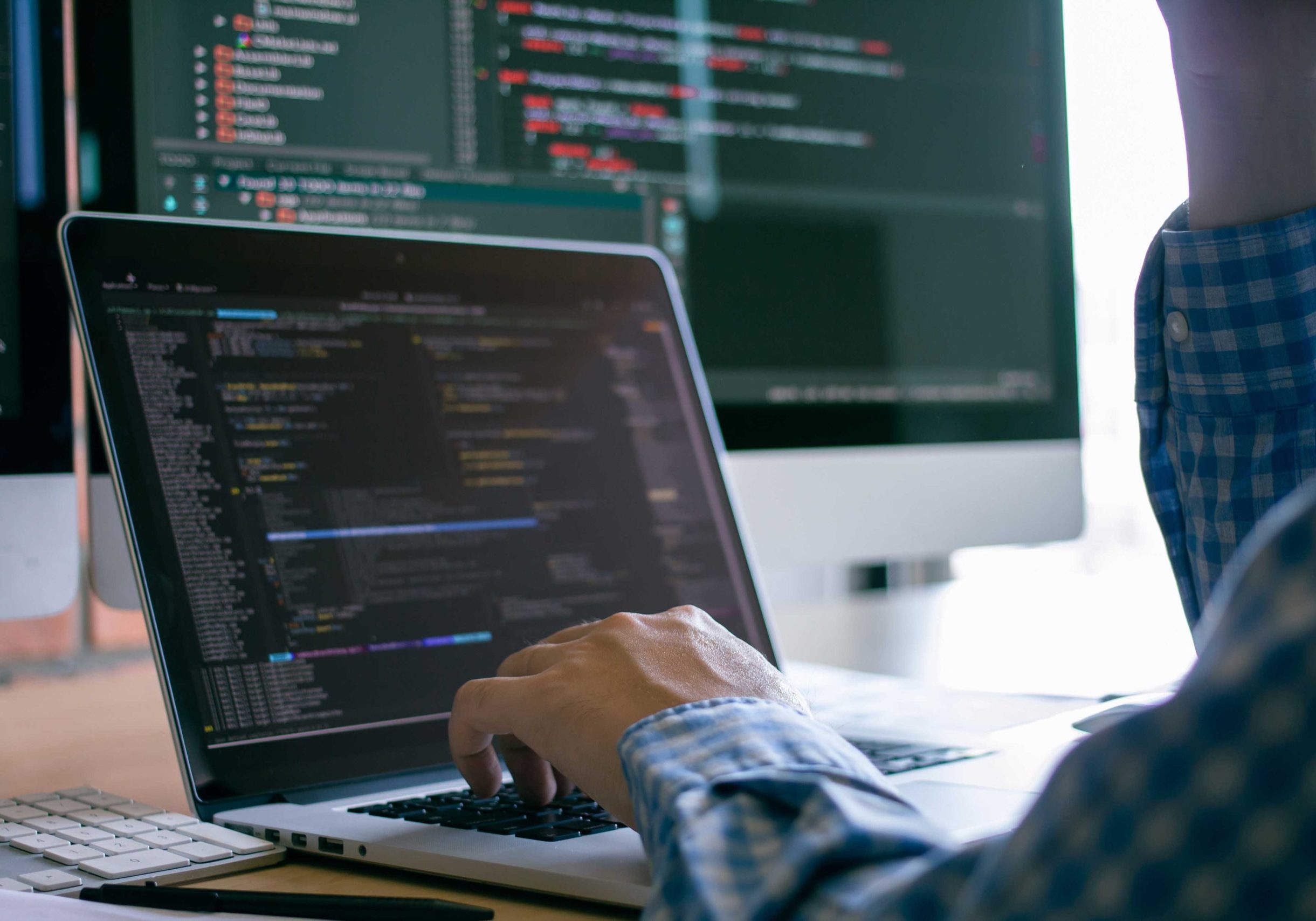 A developer on a laptop sorting through various files of code